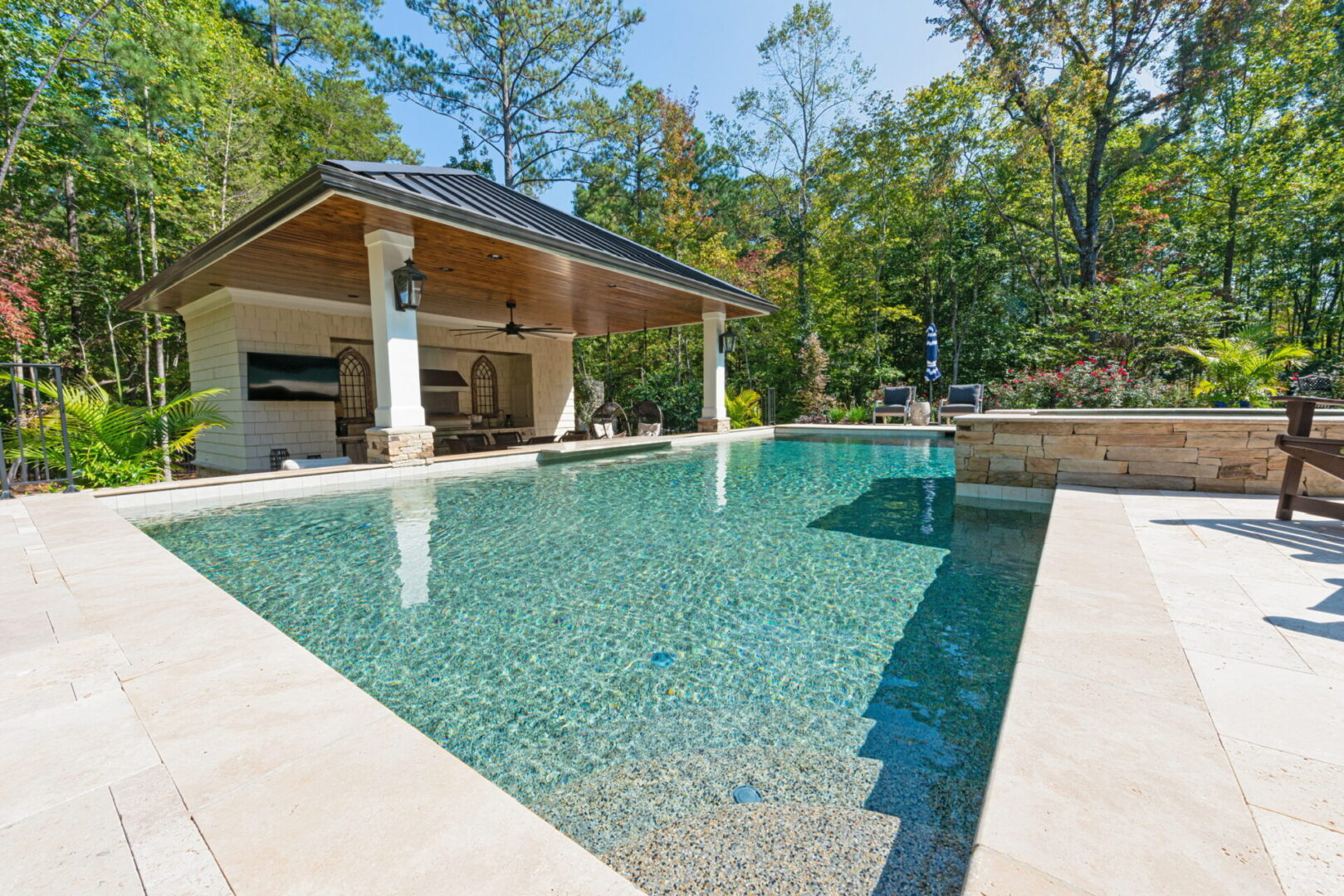 A luxury villa with a pool space and sitting chairs